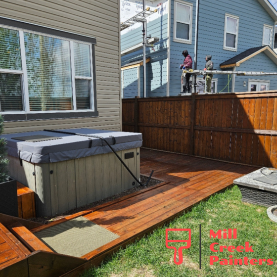 Freshly stained deck and fence in Panorama Hills, Calgary with rich natural wood finish and hot tub surround.